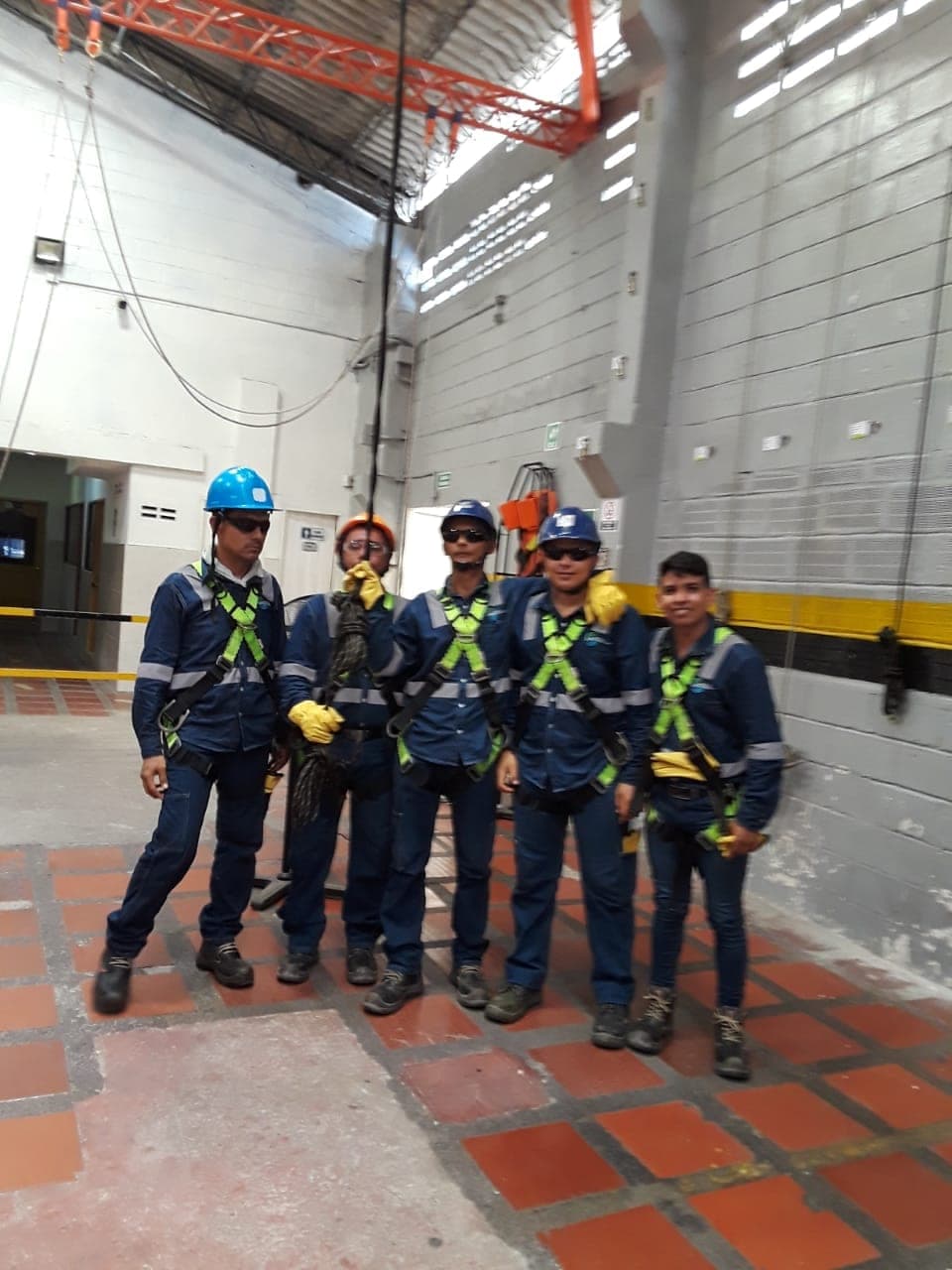 Cuadrilla de técnicos de Grupo S&M con cascos y arneses en planta industrial