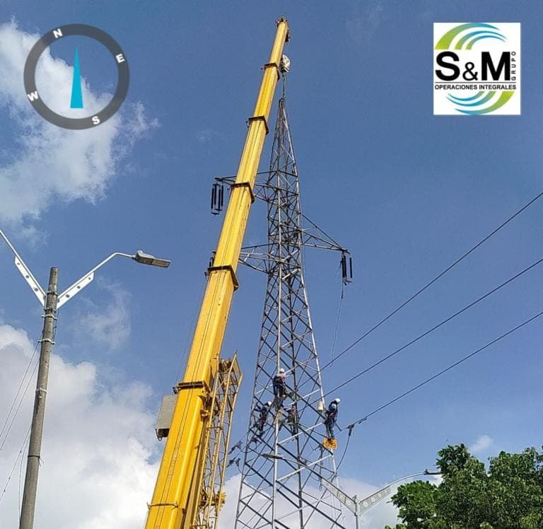 Grúa telescópica y linieros de Grupo S&M en mantenimiento de la línea 706 sobre una torre de alta tensión en Barranquilla