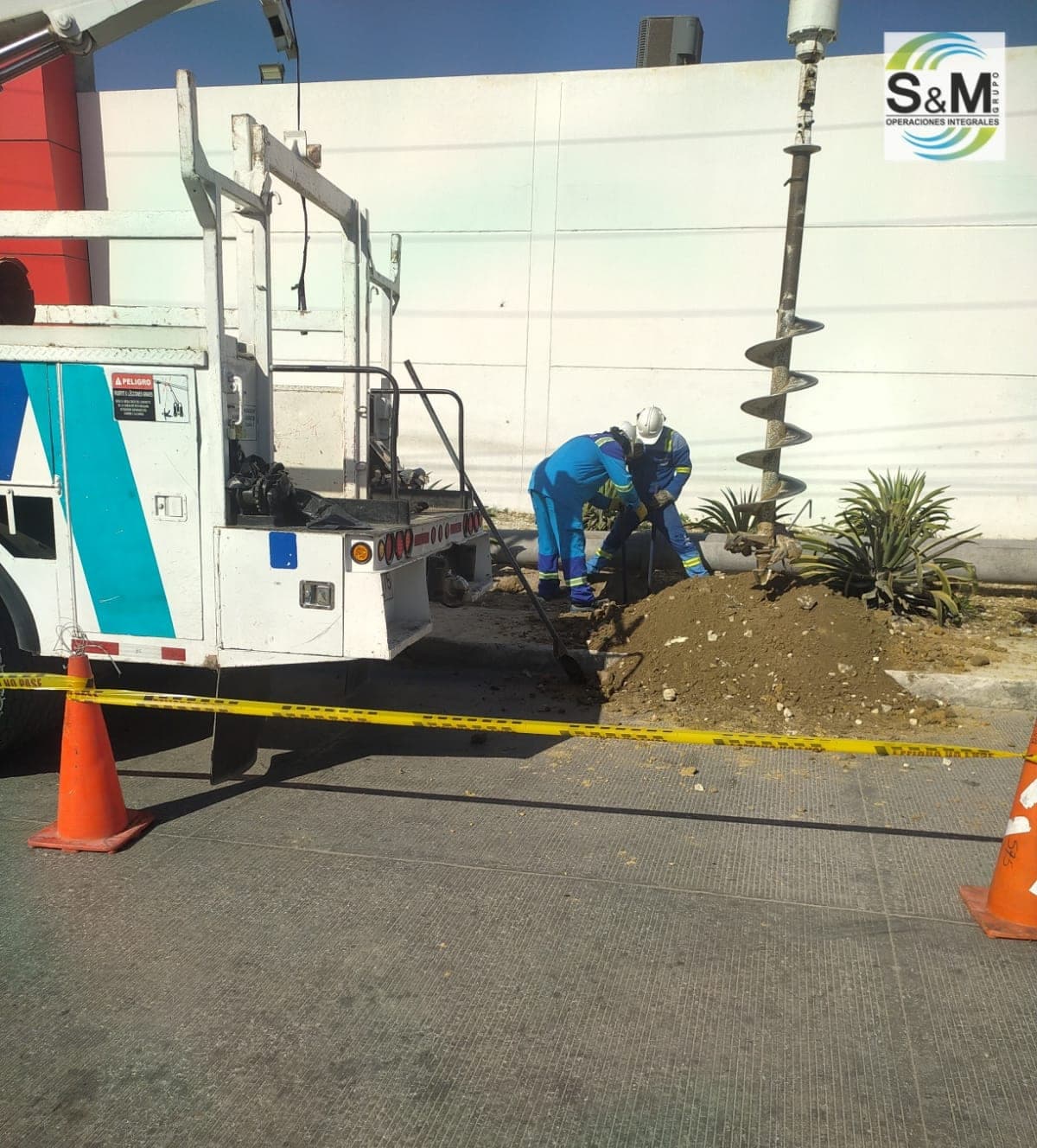 Camión grúa con barreno helicoidal de Grupo S&M perforando terreno para hincar poste
