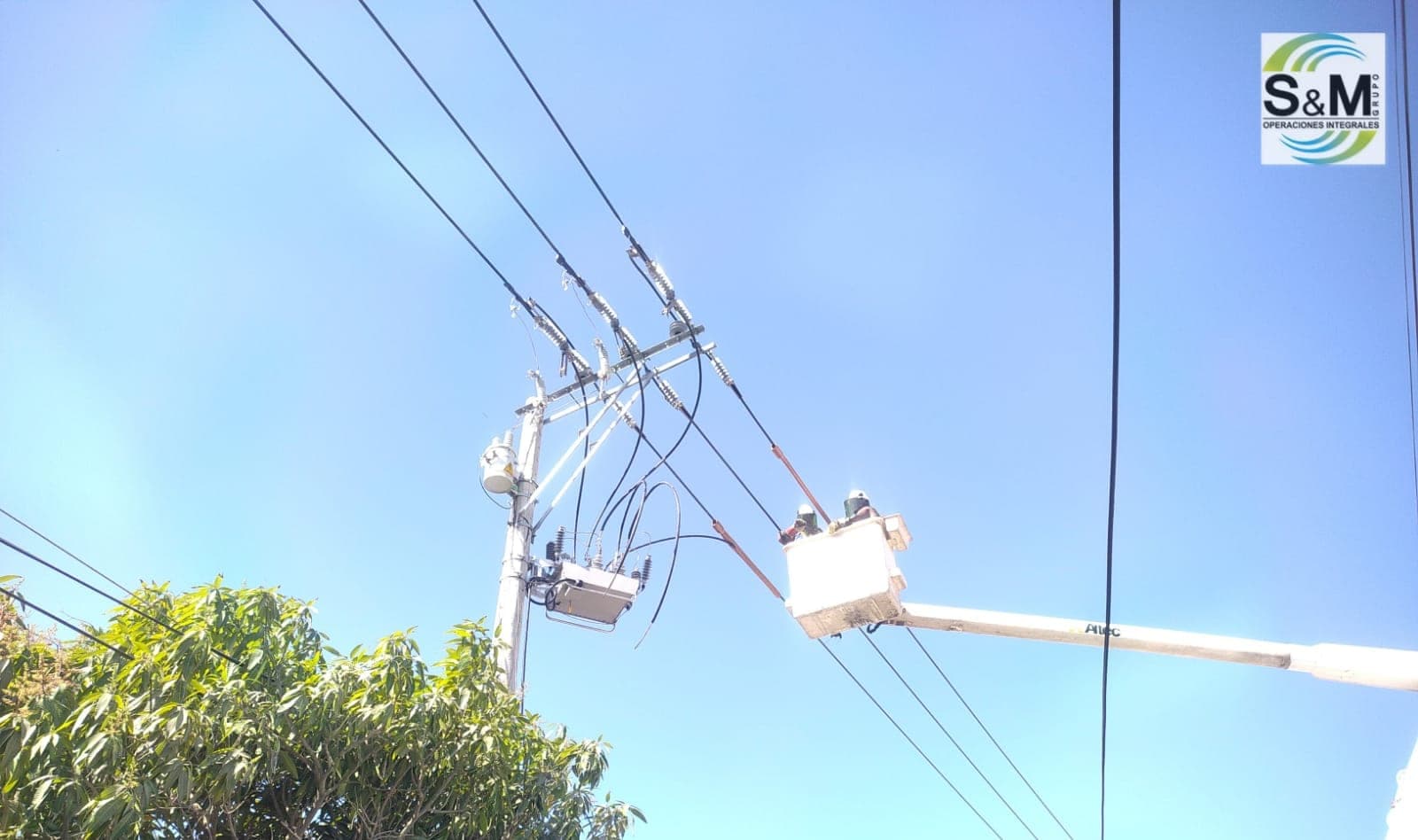 Linieros de Grupo S&M trabajando con pértigas sobre transformador de media tensión