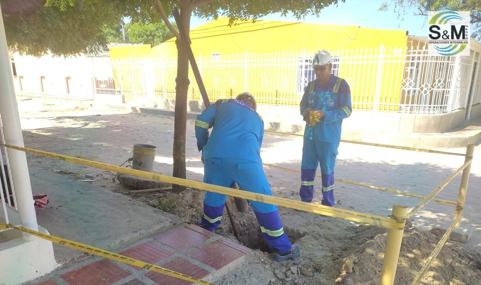 Operarios de Grupo S&M excavando cimentación para poste con señalización de seguridad en Soledad